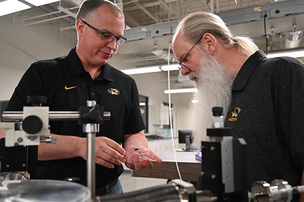 Matt Maschmann and Tommy Sewell stand in a lab