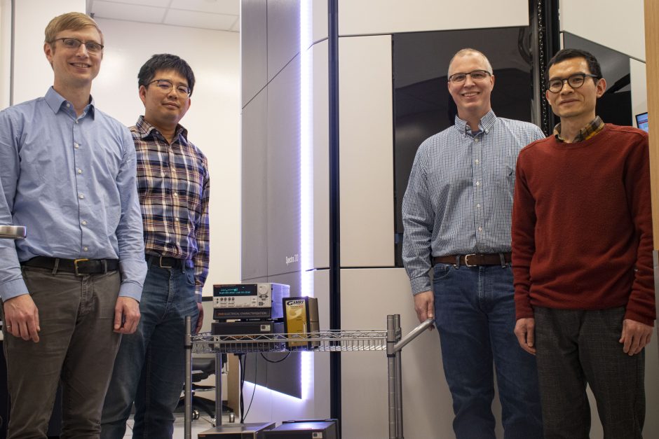 Portrait of engineers in front of an electron microscope